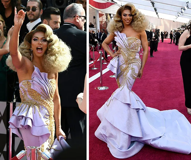 Person in a glamorous, strapless lilac gown with gold details, posing on the red carpet.