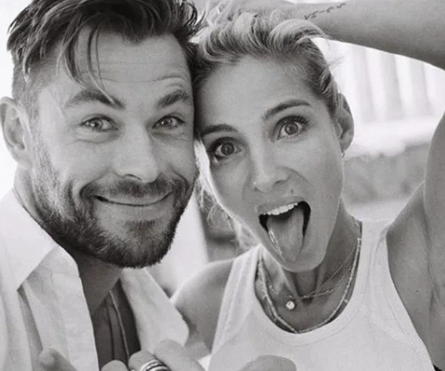 A black-and-white photo of a smiling man and woman making playful faces at the camera.