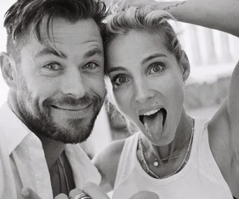 A black-and-white photo of a smiling man and woman making playful faces at the camera.