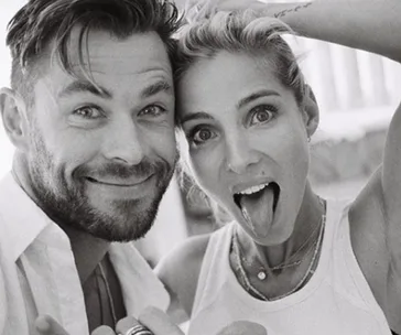 A black-and-white photo of a smiling man and woman making playful faces at the camera.