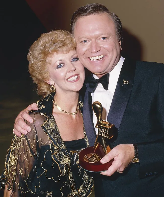 Couple smiling, man holding a TV Week Logie award.