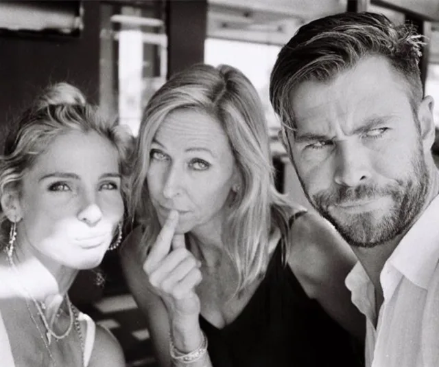 Three people posing for a black and white selfie, two women and one man, in an outdoor setting.
