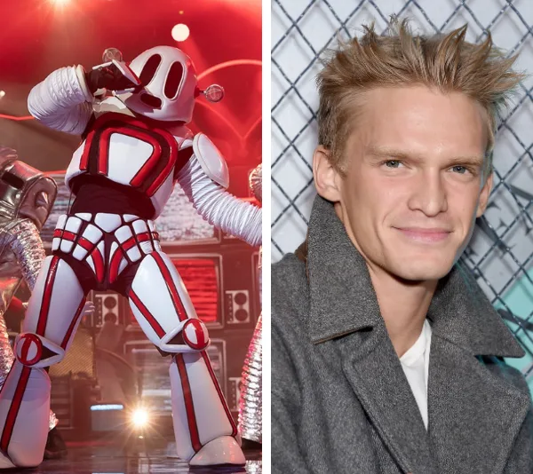 Robot costume from "The Masked Singer Australia" next to a young man with light hair wearing a gray coat.