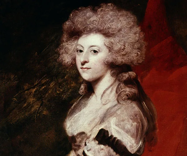 Portrait of a woman with curly white hair in an elaborate hairstyle, wearing a formal dress, set against a dark background.