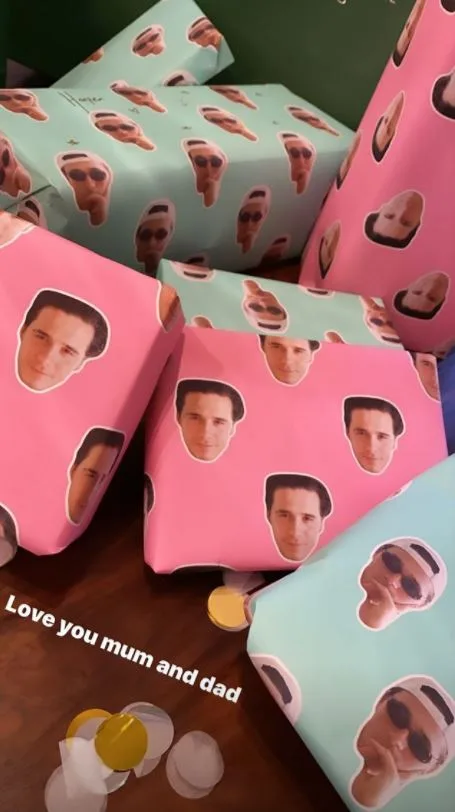 Gift boxes wrapped in pink and green paper with face stickers, reading "Love you mum and dad" at the bottom.