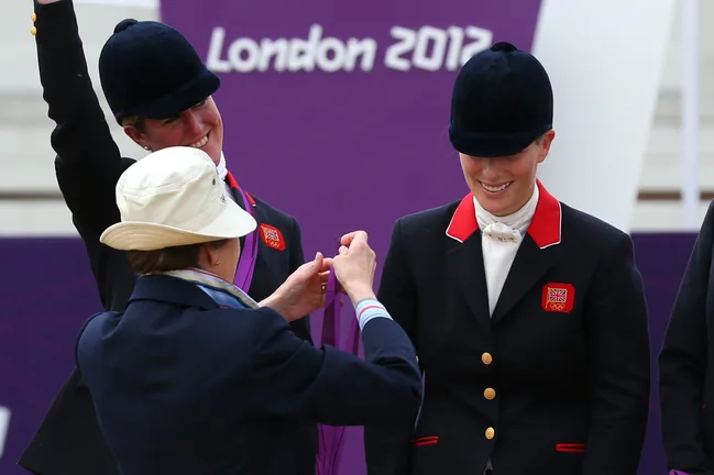 Medals being awarded to equestrian athletes at London 2012 Olympics, with a purple backdrop.