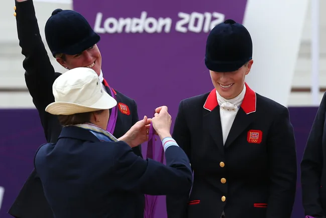 Medals being awarded to equestrian athletes at London 2012 Olympics, with a purple backdrop.