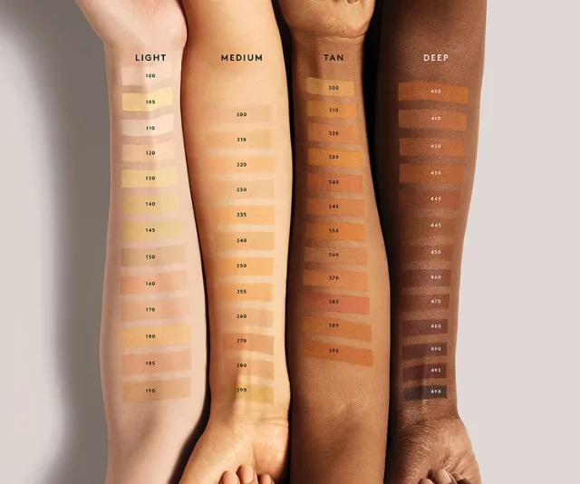 Four arms with makeup foundation swatches ranging from light to deep skin tones.