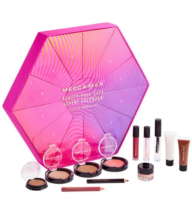 Mecca Max advent calendar with makeup items including powders, pencils, and lip products arranged in front.