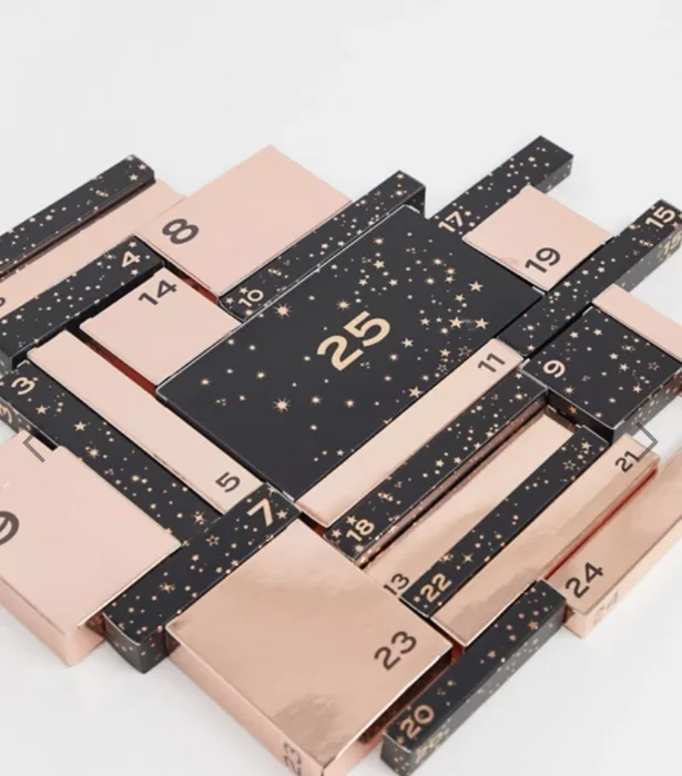 Advent calendar with numbered boxes, black and rose gold design, featuring a large box marked "25" in the center.