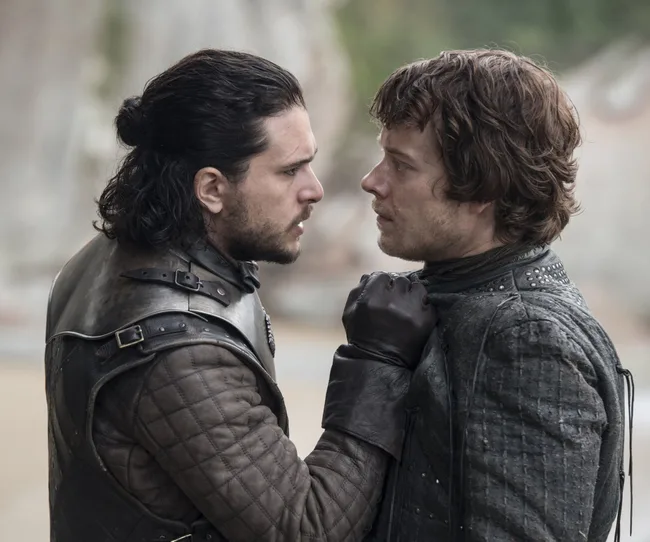 Two medieval-dressed men intensely confront each other, with one grabbing the other by the collar.