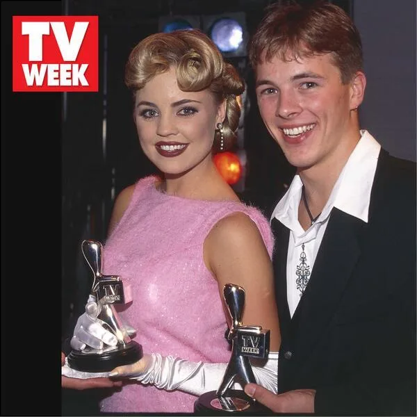 Two smiling individuals holding TV Week awards, with a TV Week logo in the top left corner.