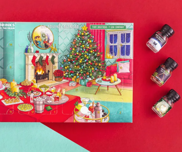 Festive gin advent calendar scene with Christmas tree, fireplace, and mini gin bottles on a red background.