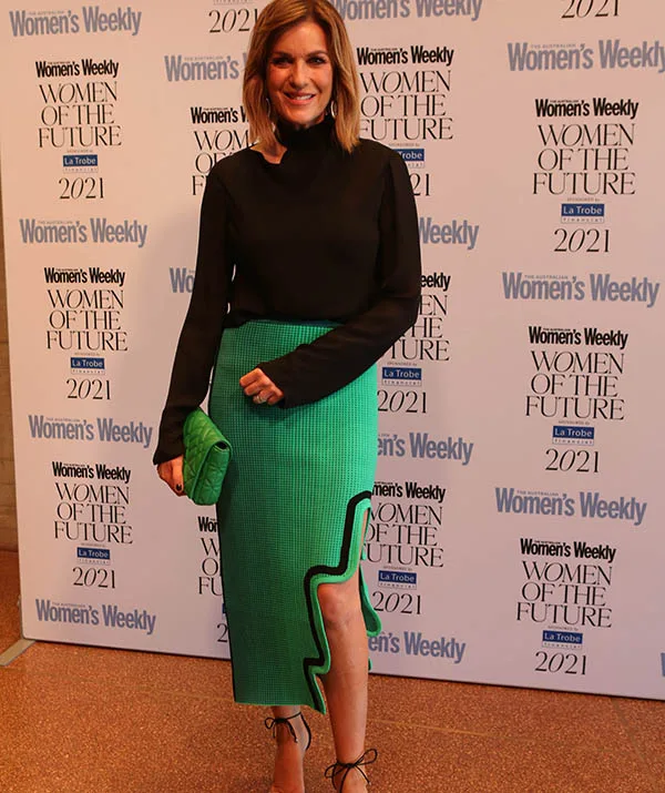 Woman in a black top and green skirt poses at Women's Weekly Women of the Future 2021 event.