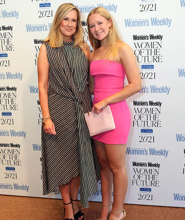 Two women posing together at the Women's Weekly Women of the Future 2021 event, one in a black dress, the other in pink.