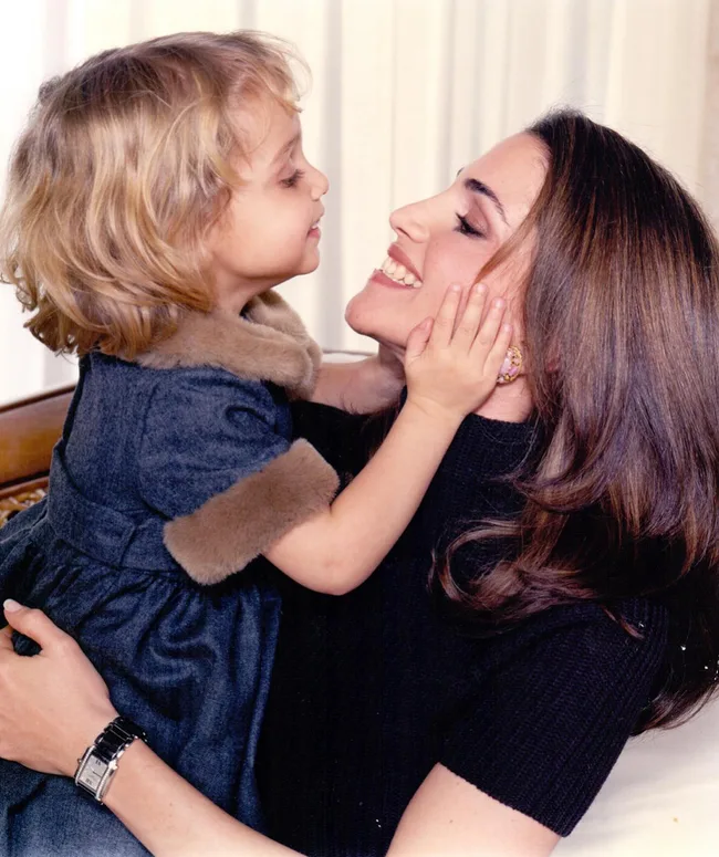 Mom and young daughter smiling in a loving embrace, highlighting warm connection and joy.
