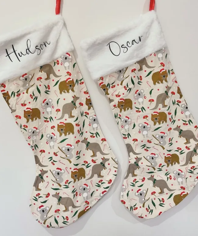 Two Christmas stockings with names "Hudson" and "Oscar," featuring koalas, kangaroos, and holiday designs.