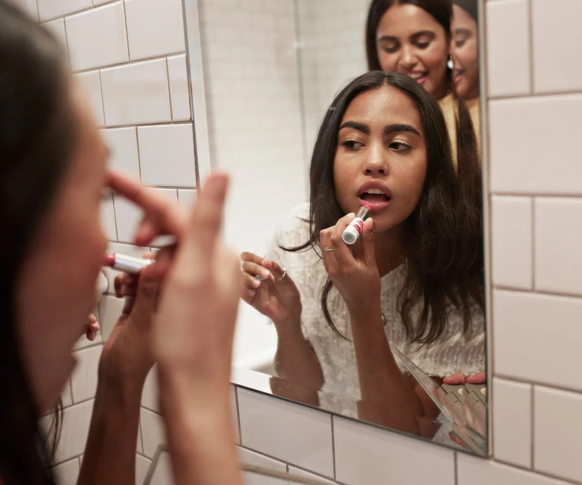 Woman using lipstick purchased during Black Friday sales