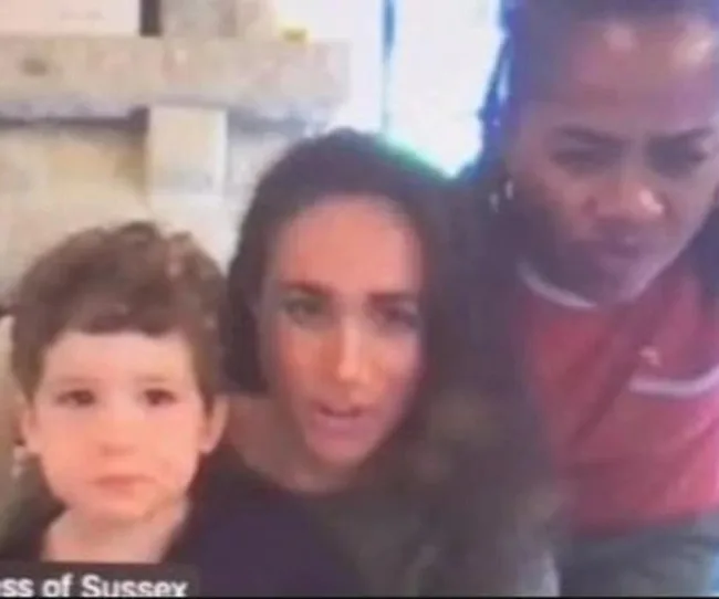 Three people, including a child and two adults, looking towards the camera with a blurred background.
