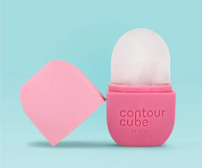 Pink Contour Cube Mini for ice facial on blue background, lid open with ice exposed.