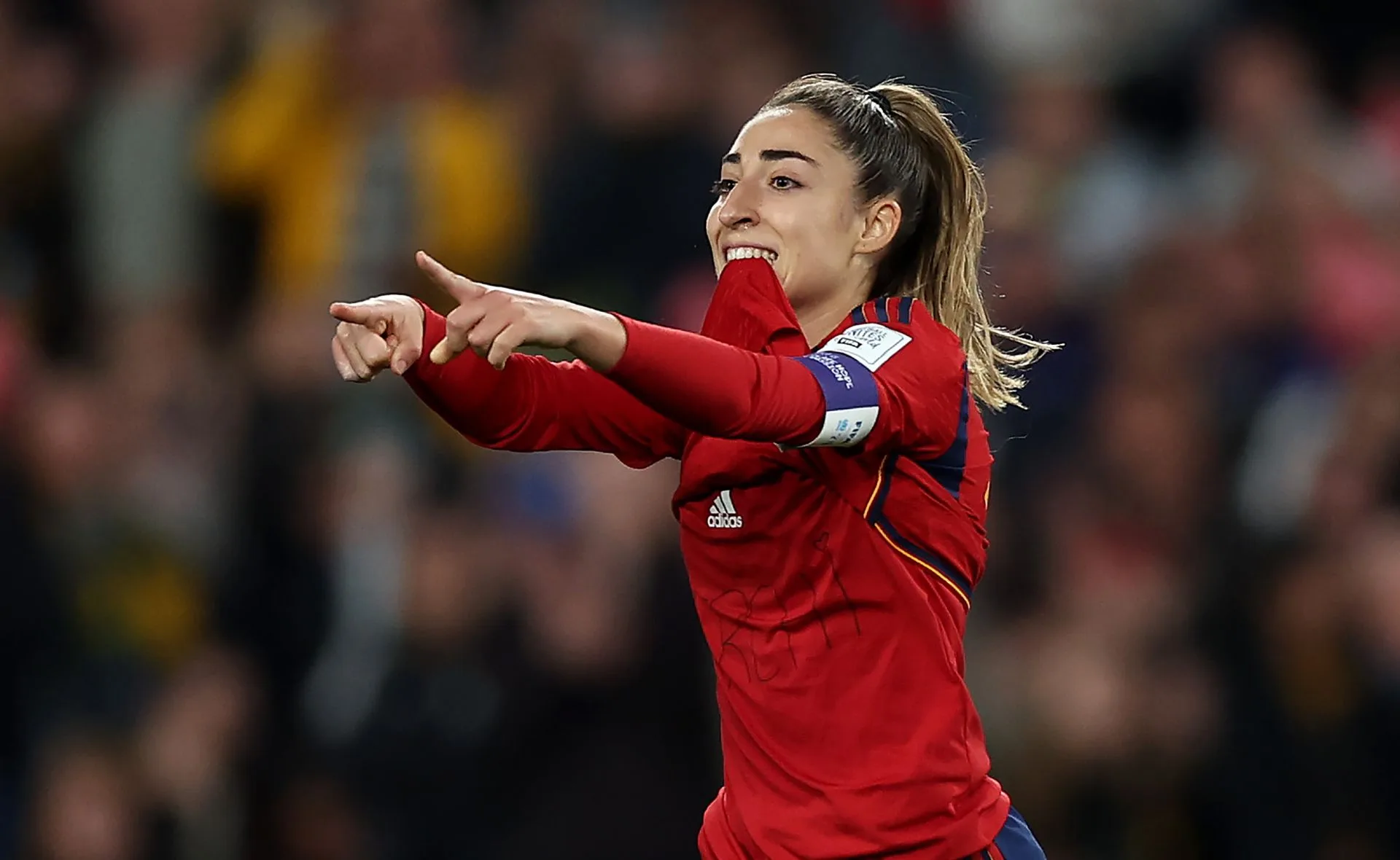 Spanish footballer celebrating a goal on the field, wearing a red jersey.