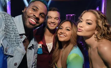 Four judges of The Voice Australia 2023 smiling and posing for a selfie on stage.