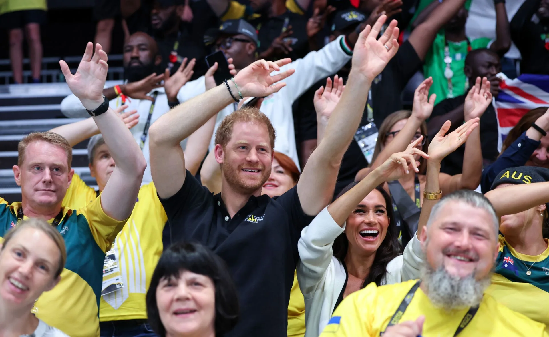 People enthusiastically cheering and raising arms at the Invictus Games.