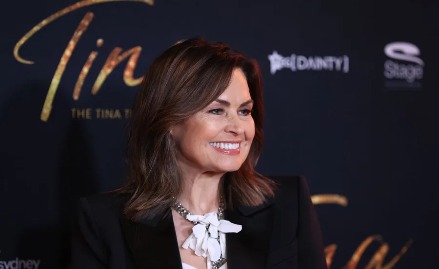 Lisa Wilkinson smiling at the premiere of "Tina: The Tina Turner Musical" in Sydney, wearing a black blazer and white blouse.