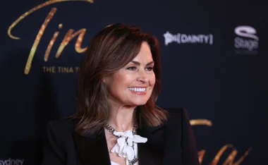 Lisa Wilkinson smiling at the premiere of "Tina: The Tina Turner Musical" in Sydney, wearing a black blazer and white blouse.