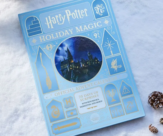 Harry Potter Holiday Magic Advent Calendar on snow with Hogwarts illustration.