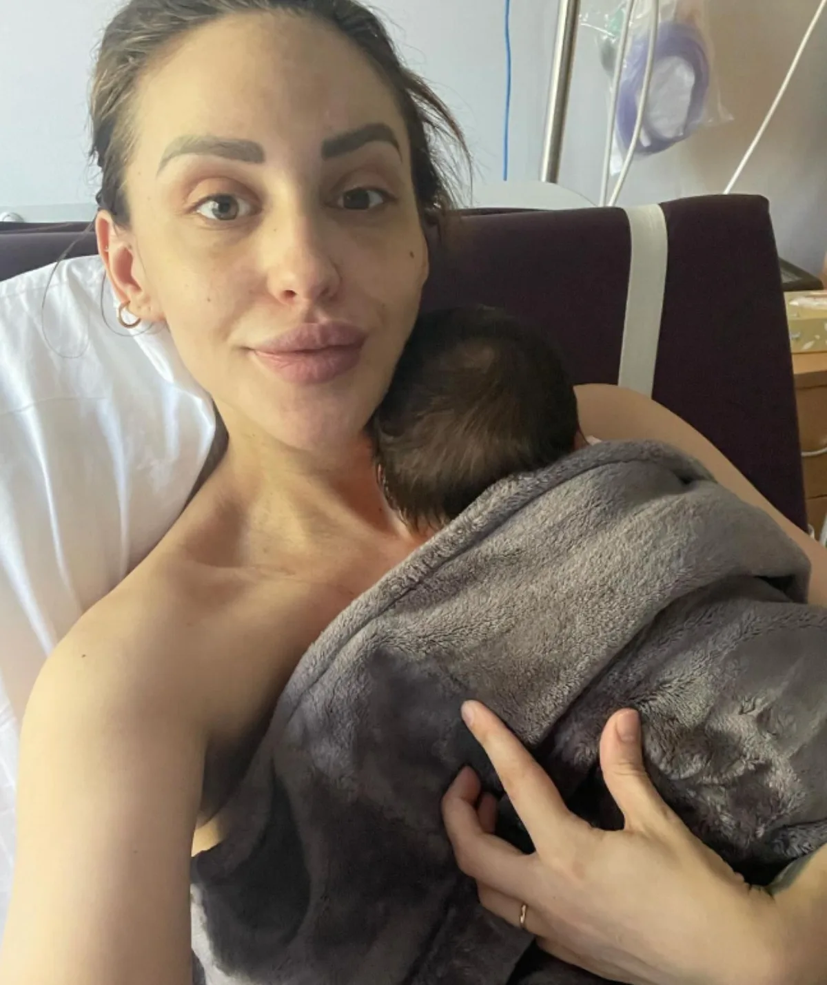 Lizzie Sobinoff holding her second child in the hospital bed