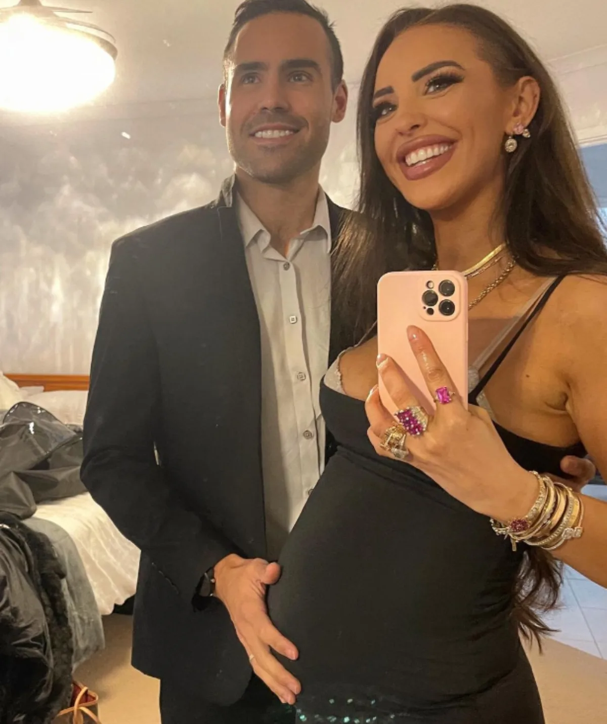 Lizzie Sobinoff with her husband's hand on her belly
