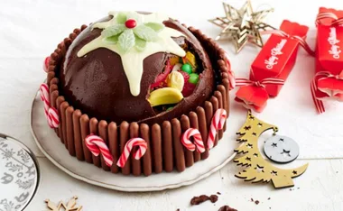 Chocolate Christmas smash cake with candy canes and a white chocolate star, revealing colorful candies inside.
