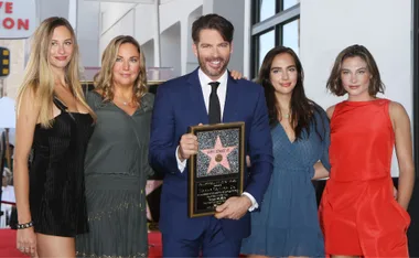 "Harry Connick Jr. with his family, holding a star plaque at a Hollywood event."