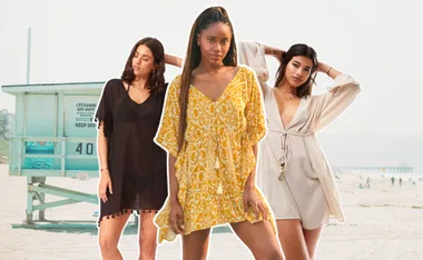 Women modeling kaftans on a beach with a lifeguard tower in the background.