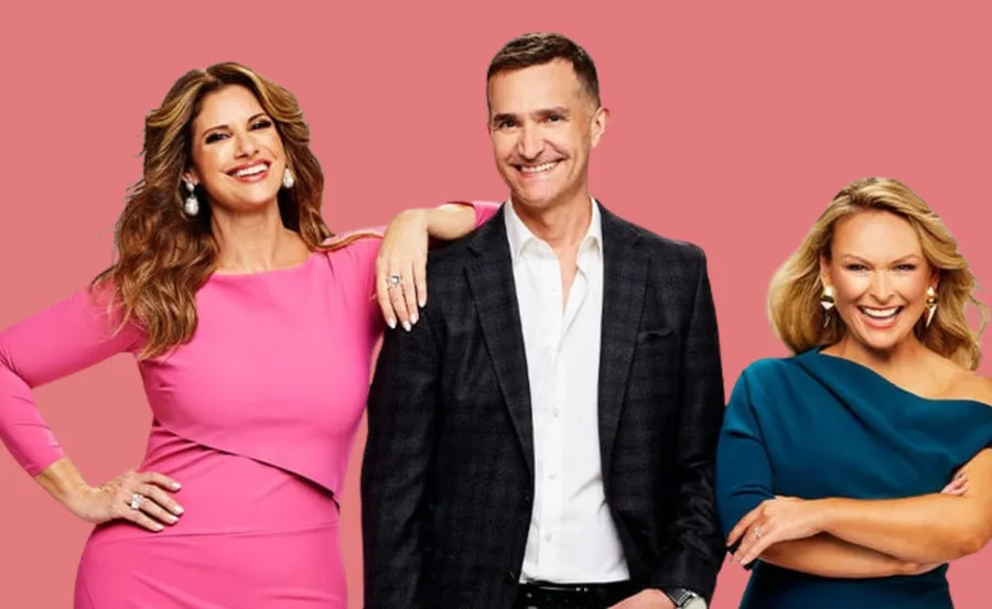 Three people posing against a pink background, smiling at the camera.