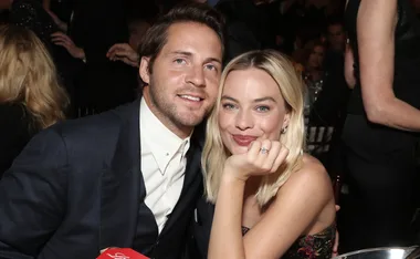 A woman with blonde hair and a man in a suit smiling and posing together at a formal event.
