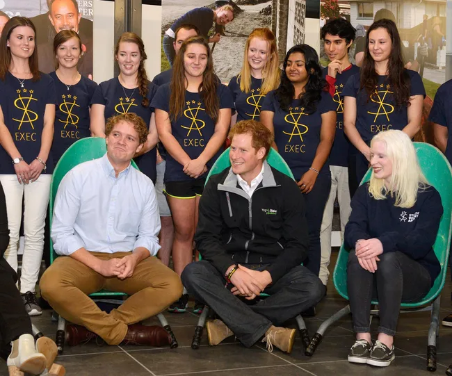 Group of people seated and standing, wearing matching "Exec" shirts, likely in a social or casual event setting.