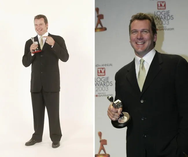 Man in formal suit holding an award, smiling at an event backdrop with "Logie Awards 2003" signage.