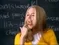 Cher Horowitz from "Clueless" eating candy in a classroom, wearing a yellow outfit with a chalkboard in the background.