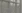 Raindrops streaming down a window with a blurred view outside.