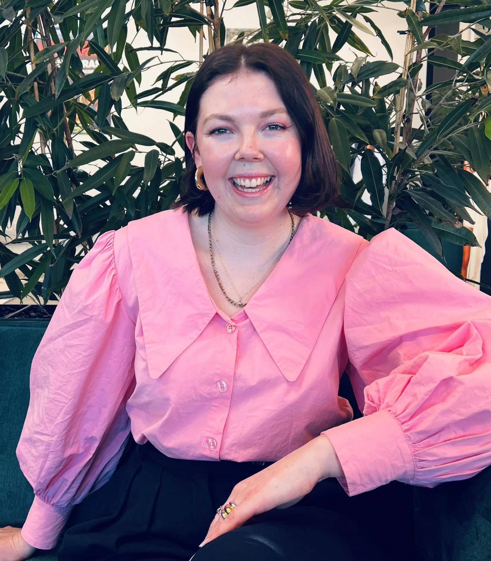 Rebekah Hebenton wearing pink shirt sitting on couch