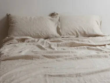 Light cool sheets in natural oat on a bed