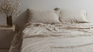 Light cool sheets in natural oat on a bed