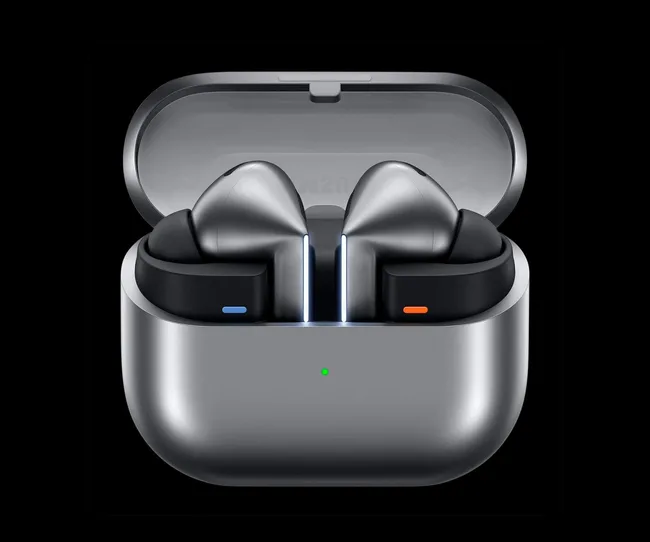 Silver wireless earbuds in an open charging case with a green LED indicator on the front.