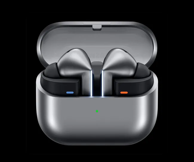 Silver wireless earbuds in an open charging case with a green LED indicator on the front.