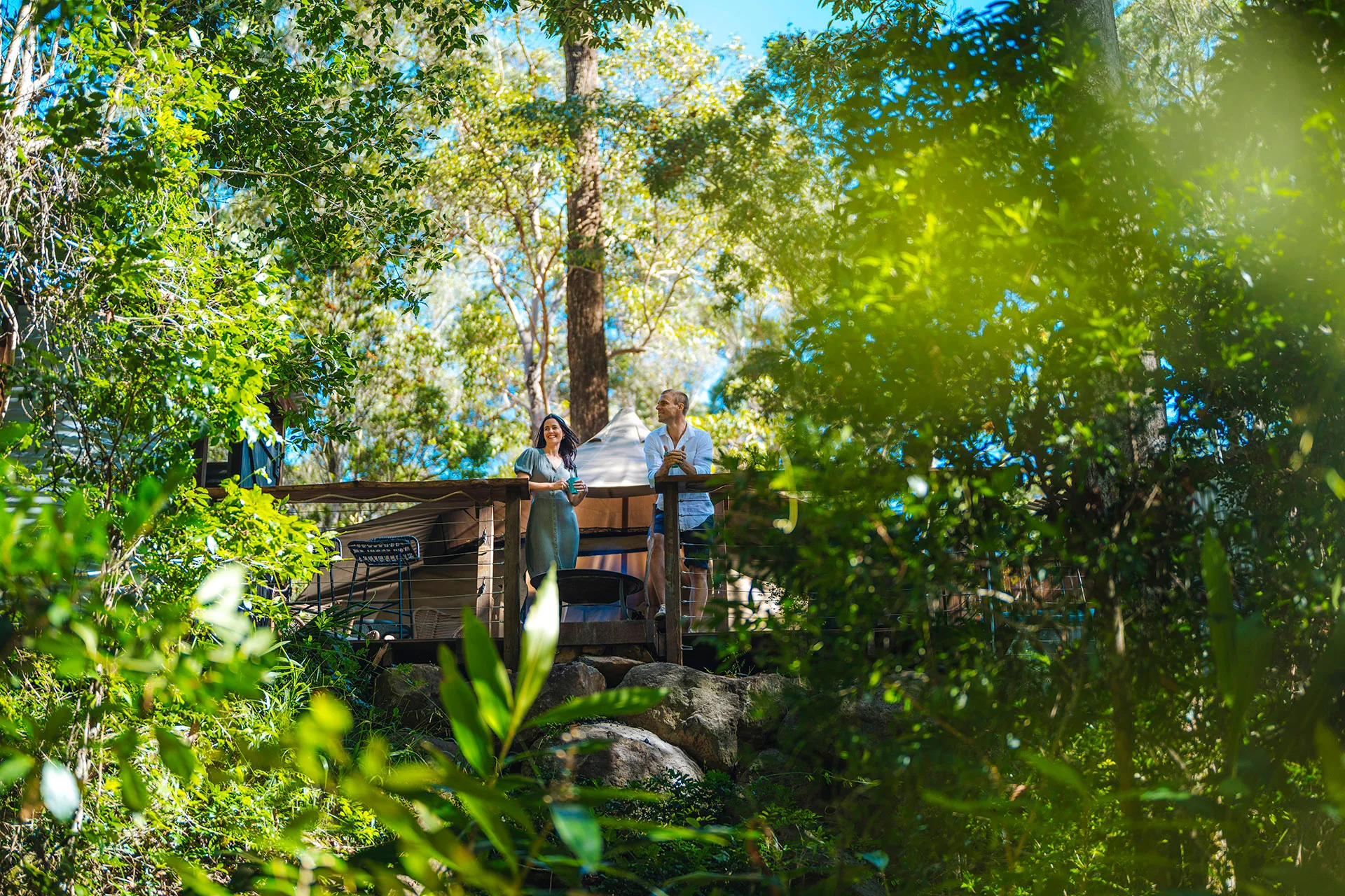 Couple standing outside of their glamping tent at Cedar Creek Lodges