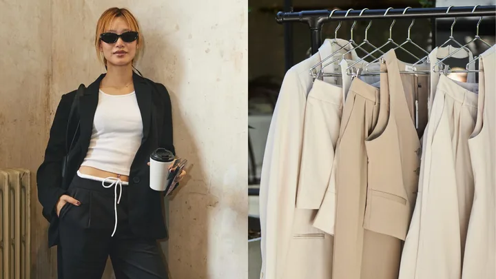 Person in black blazer with coffee cup on left; beige suits on hangers on right.