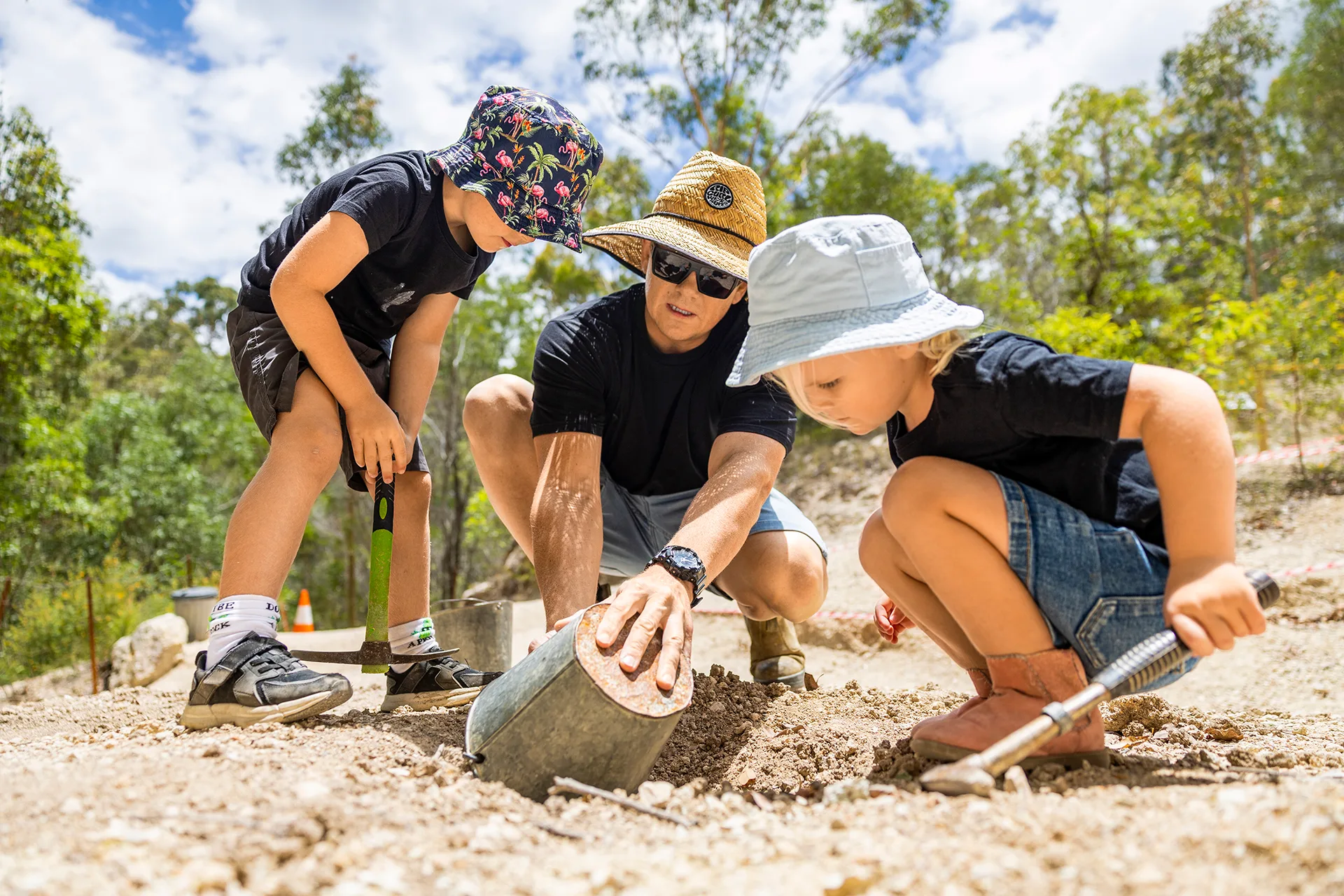 Two kids and dad digging