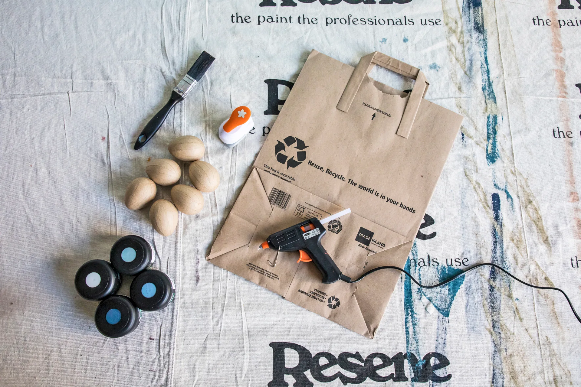Craft project equipment, paint, eggs, hot glue gun, paint brush